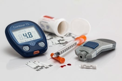 Diabetes care setup with a glucose meter reading 4.8, an insulin pen, and other medicines