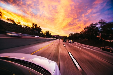 Fast-moving car on a highway, with the scene in front intentionally blurred to emphasize speed