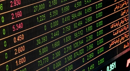 A digital stock market ticker board showing glowing green and red numbers, representing stock price changes