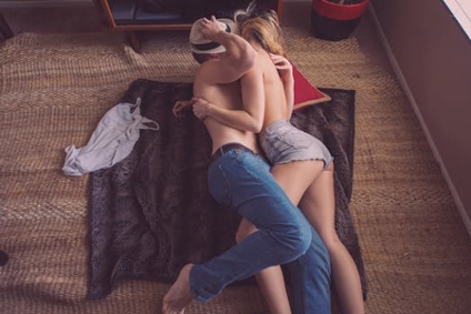 A couple cuddling closely together on the floor
