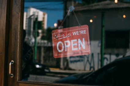 Storefront entrance with an “Open” sign hanging at the door