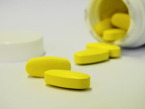 Yellow pills spilling out from a container