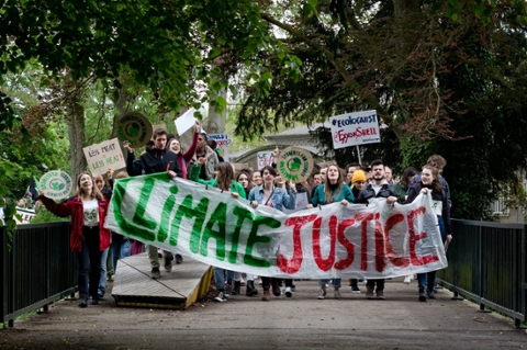 Young protesters holding a sign that says, 'Climate Justice'