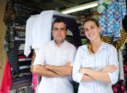 A man and a young girl stand closely, shoulder to shoulder in a clothing retail store
